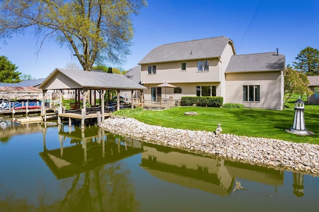 rear view of house with a shingled roof, boat lift, a water view, and a yard
