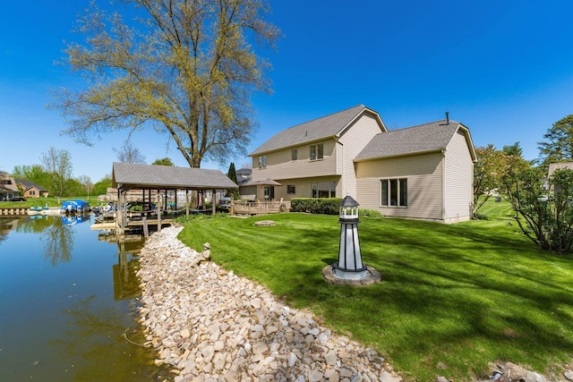 rear view of house featuring a water view and a yard