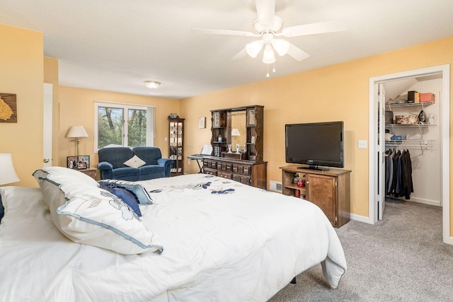 bedroom with a walk in closet, a ceiling fan, visible vents, baseboards, and light carpet