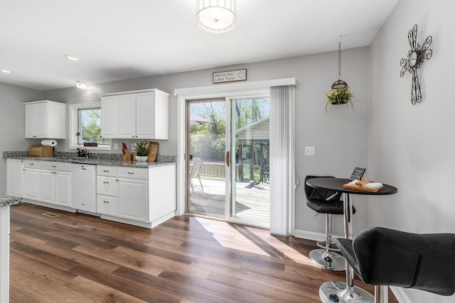 kitchen featuring white dishwasher, dark wood-style floors, recessed lighting, white cabinets, and light stone counters