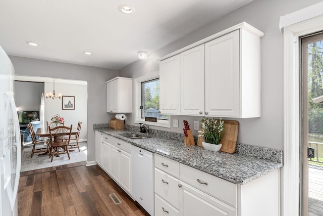 kitchen featuring dark wood-style flooring, visible vents, white dishwasher, a sink, and white cabinetry