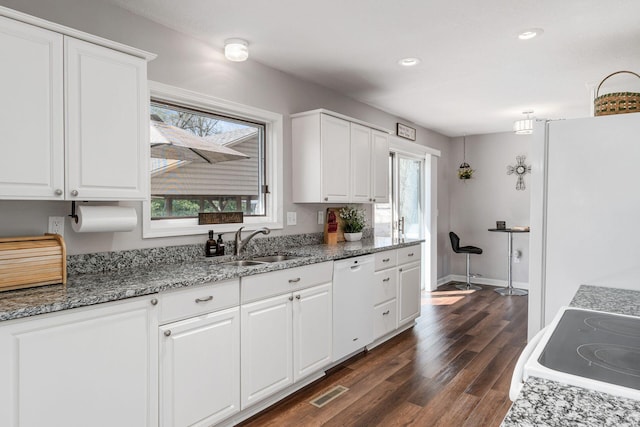 kitchen with white appliances, white cabinetry, and a sink