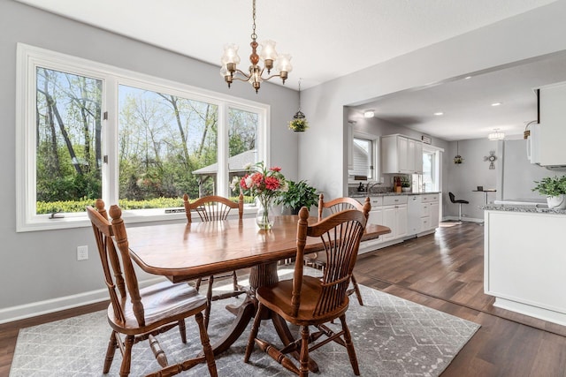 dining space with an inviting chandelier, baseboards, recessed lighting, and dark wood-type flooring