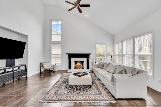 7169 Fernridge Dr, New Albany, OH 43054 - living room featuring high vaulted ceiling, plenty of natural light, a ceiling fan, a warm lit fireplace, and baseboards
