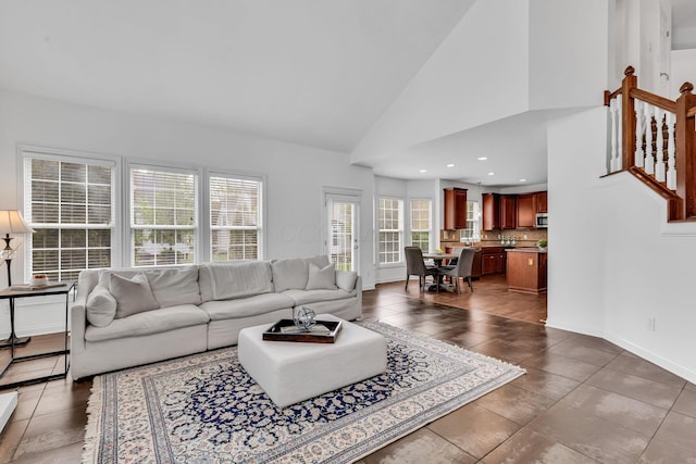 7169 Fernridge Dr, New Albany, OH 43054 - living area with plenty of natural light, dark tile patterned floors, stairway, baseboards, and vaulted ceiling
