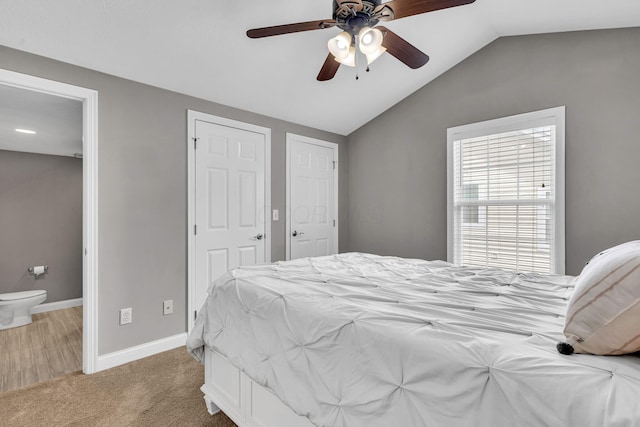 7169 Fernridge Dr, New Albany, OH 43054 - carpeted bedroom with vaulted ceiling, baseboards, a ceiling fan, multiple closets, and ensuite bath