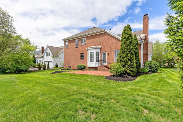 7169 Fernridge Dr, New Albany, OH 43054 - rear view of property with brick siding, a yard, and a chimney