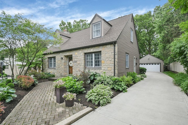 1799 Baldridge Rd, Columbus, OH 43221 - cape cod home with stone siding, a detached garage, an outbuilding, a shingled roof, and a chimney