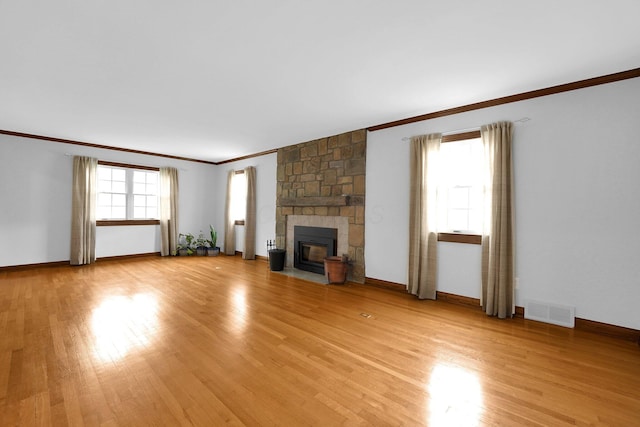 1799 Baldridge Rd, Columbus, OH 43221 - unfurnished living room featuring crown molding, light wood-style flooring, a stone fireplace, and baseboards