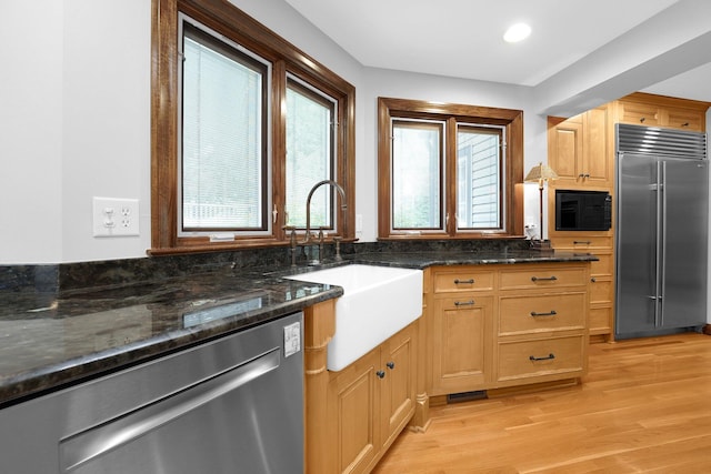 1799 Baldridge Rd, Columbus, OH 43221 - kitchen with built in appliances, a sink, light wood-style flooring, dark stone counters, and recessed lighting