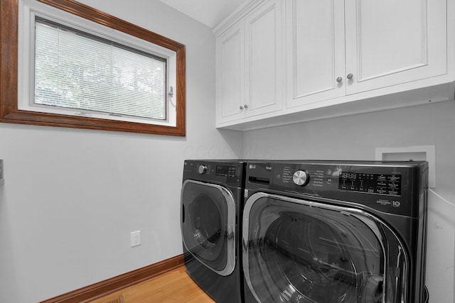1799 Baldridge Rd, Columbus, OH 43221 - washroom featuring washer and dryer, cabinet space, baseboards, and light wood-type flooring