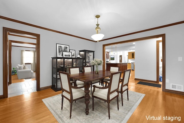 1799 Baldridge Rd, Columbus, OH 43221 - dining space featuring baseboards, crown molding, and light wood-style floors