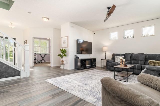 living area with stairs, wood finished floors, and baseboards