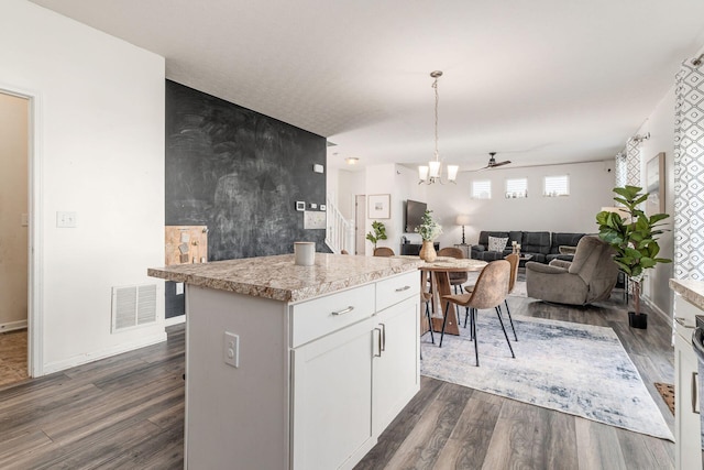 kitchen with a center island, dark wood-style floors, white cabinets, and open floor plan