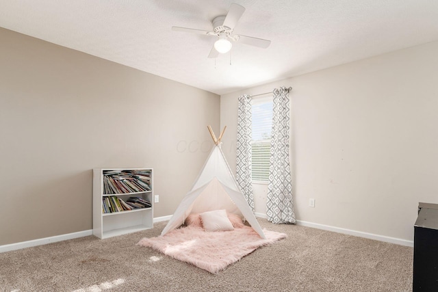 playroom with carpet, ceiling fan, and baseboards