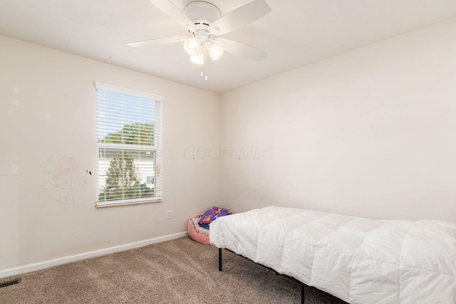 carpeted bedroom featuring baseboards and ceiling fan