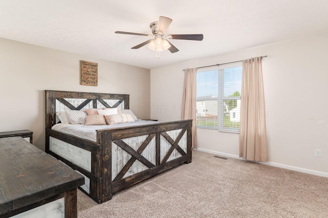 bedroom with light colored carpet, baseboards, and a ceiling fan
