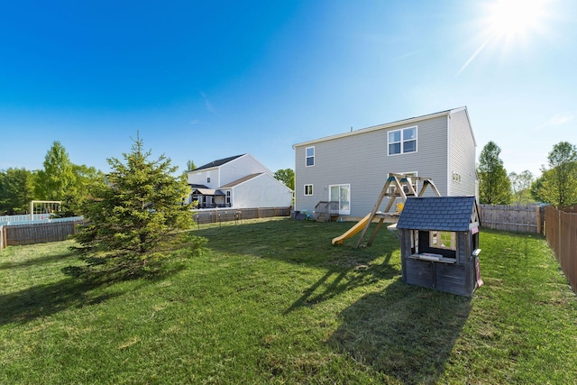 rear view of property with a playground