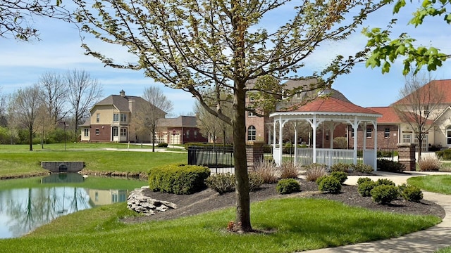view of community featuring a gazebo, a water view, and a yard