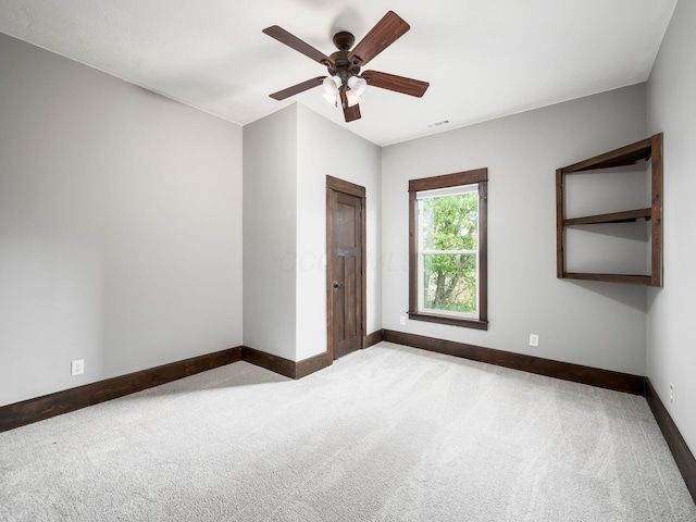 unfurnished room featuring baseboards, carpet, and ceiling fan