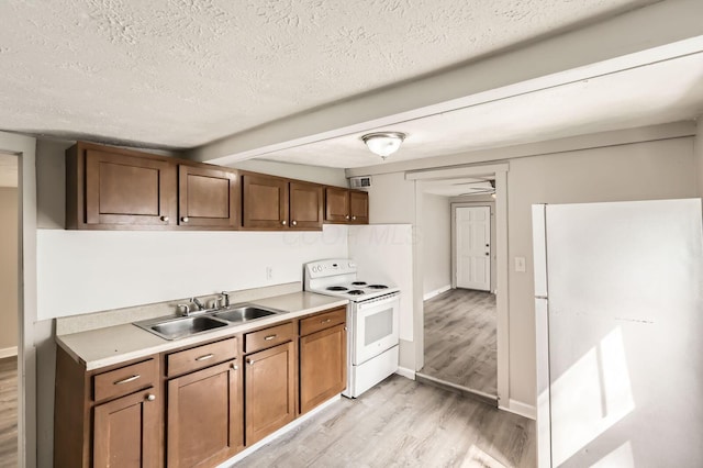 1273 Minnesota Ave, Columbus, OH 43211 - kitchen featuring white appliances, a sink, light wood-type flooring, a textured ceiling, and light countertops