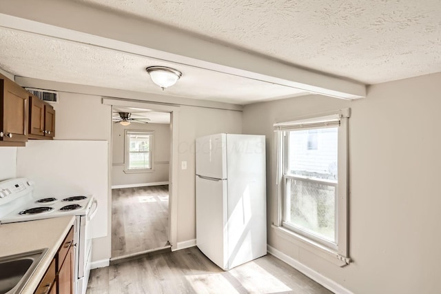 1273 Minnesota Ave, Columbus, OH 43211 - kitchen with white appliances, brown cabinets, light wood-style flooring, a ceiling fan, and a textured ceiling