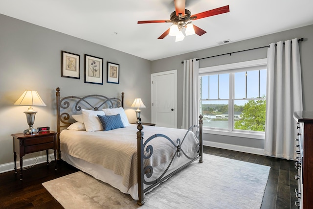bedroom featuring baseboards, a ceiling fan, visible vents, and dark wood-style floors