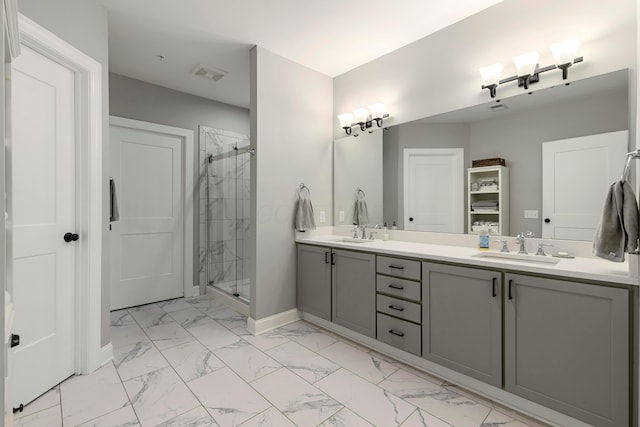 bathroom with a stall shower, marble finish floor, visible vents, and a sink