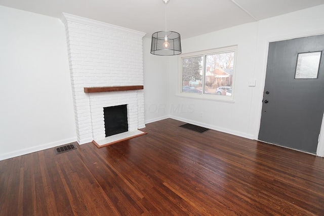 unfurnished living room featuring baseboards, visible vents, wood finished floors, and a fireplace