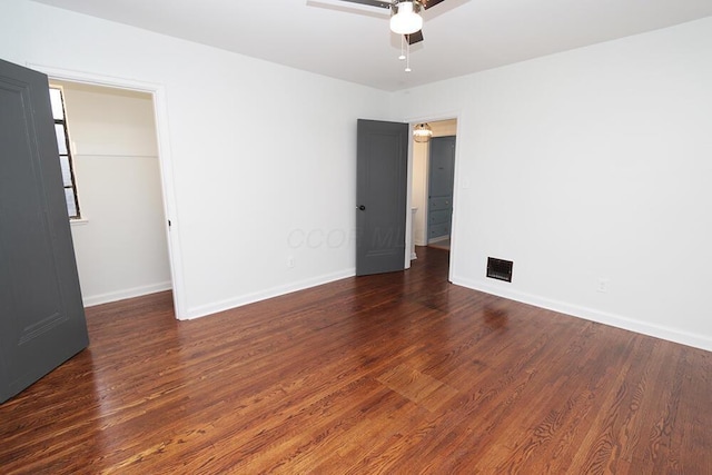 spare room featuring baseboards, ceiling fan, wood finished floors, and visible vents