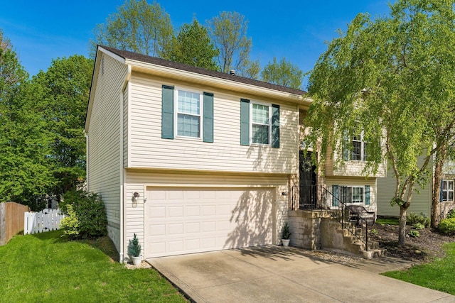 bi-level home with fence, an attached garage, concrete driveway, and a front yard