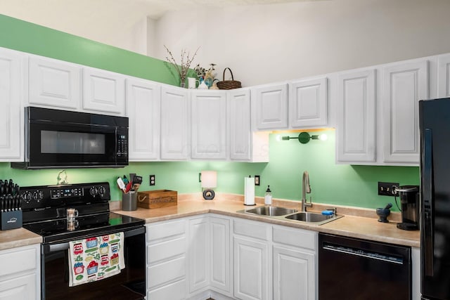 kitchen with a sink, light countertops, white cabinets, and black appliances