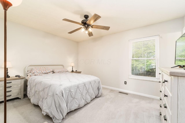 bedroom featuring light colored carpet, baseboards, visible vents, and ceiling fan