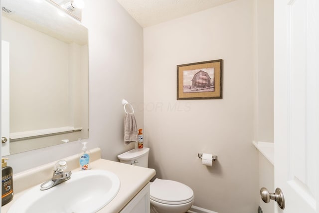 bathroom featuring vanity, baseboards, and toilet