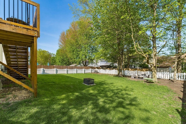 view of yard featuring a fenced backyard, a fire pit, and stairway