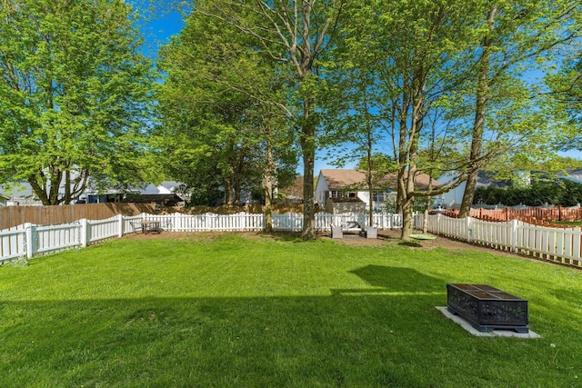 view of yard with a fenced backyard and an outdoor fire pit