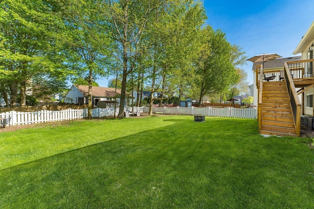 view of yard featuring a fenced backyard, stairway, and a deck