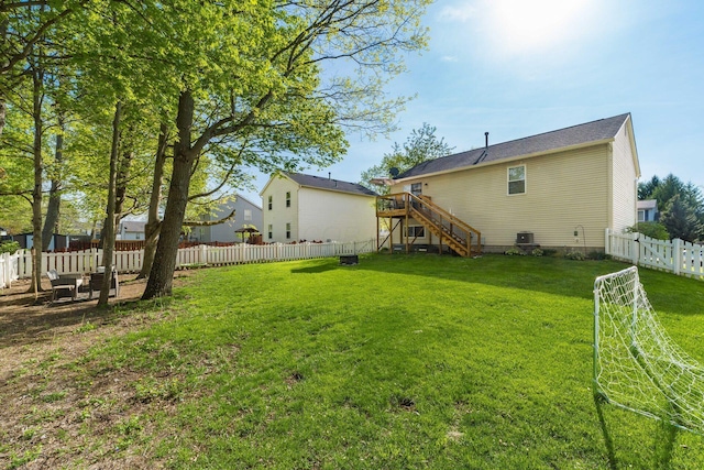 rear view of house with a fenced backyard, stairs, and a wooden deck