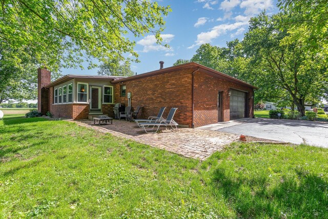 333 Salem Rd, Caledonia, OH 43314 - rear view of property featuring driveway, a chimney, brick siding, a lawn, and entry steps