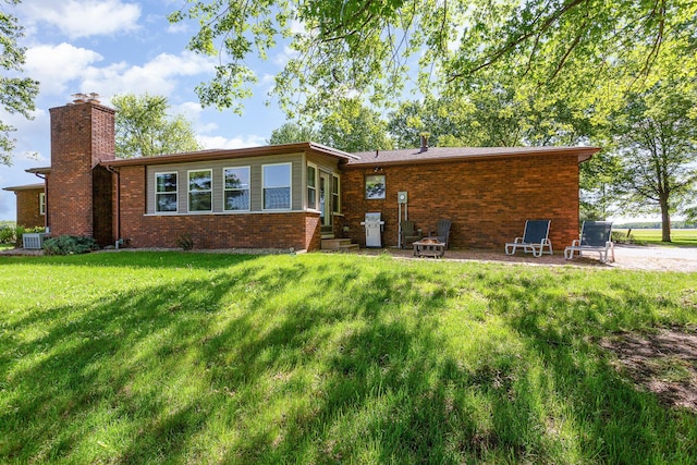 333 Salem Rd, Caledonia, OH 43314 - back of house featuring a chimney, entry steps, a lawn, brick siding, and cooling unit