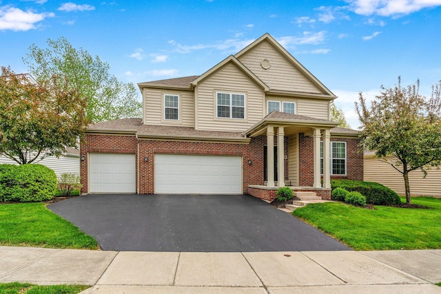 traditional home featuring brick siding, an attached garage, driveway, and a front yard