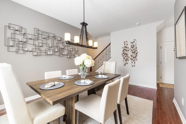 dining room featuring an inviting chandelier, baseboards, and wood finished floors