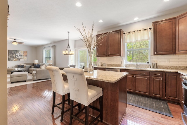 kitchen with a kitchen bar, dark wood-style floors, a sink, and tasteful backsplash