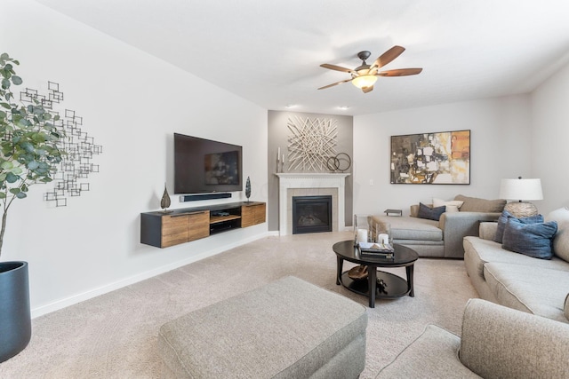 carpeted living area featuring baseboards, a ceiling fan, and a tile fireplace