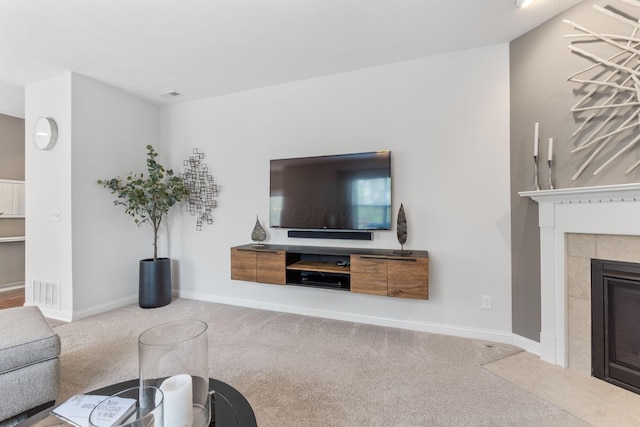living room with carpet floors, baseboards, visible vents, and a tile fireplace