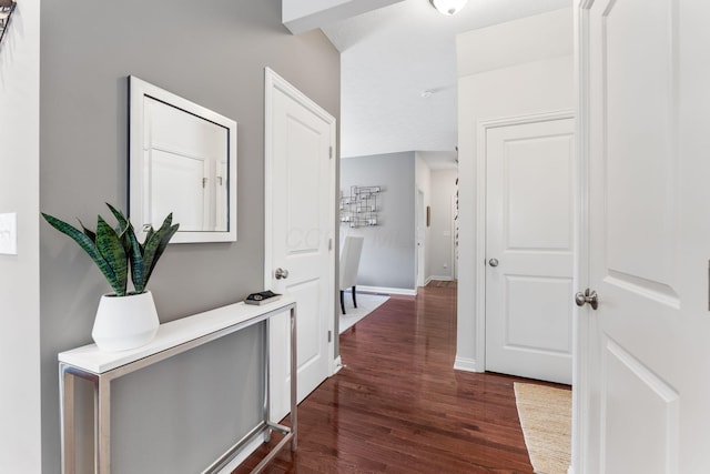 hallway with baseboards and dark wood-style floors