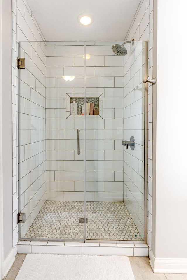 full bathroom with tile patterned flooring, baseboards, and a stall shower