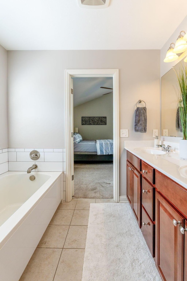 bathroom featuring double vanity, connected bathroom, a bath, tile patterned floors, and a sink