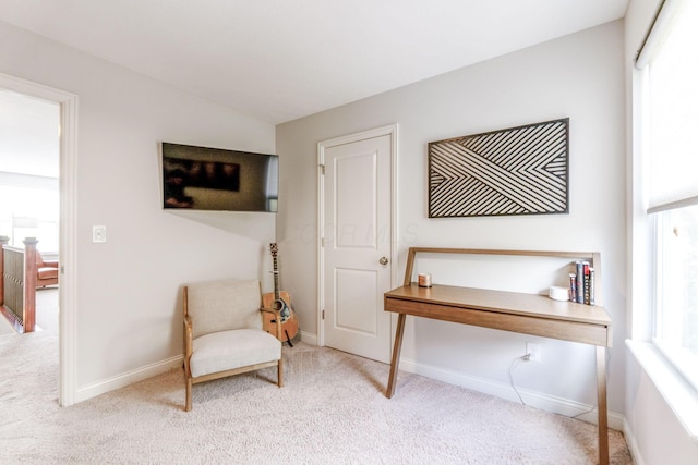 living area with baseboards, a healthy amount of sunlight, and carpet