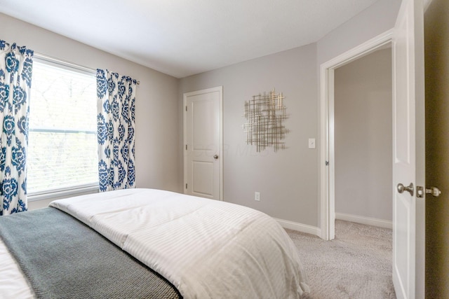 bedroom with baseboards and light colored carpet
